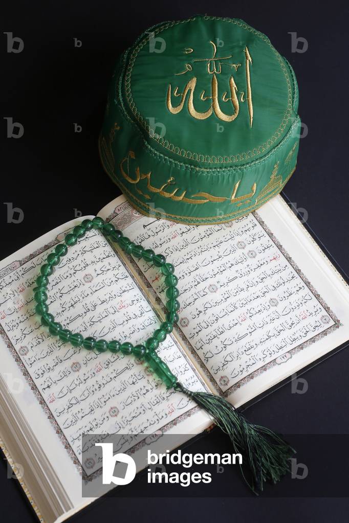 Kuran, skullcap and prayer beads. (photo)