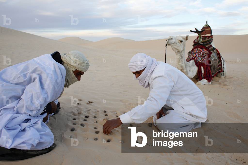 Beduins playing with stones in the sand, Douz, Tunisie