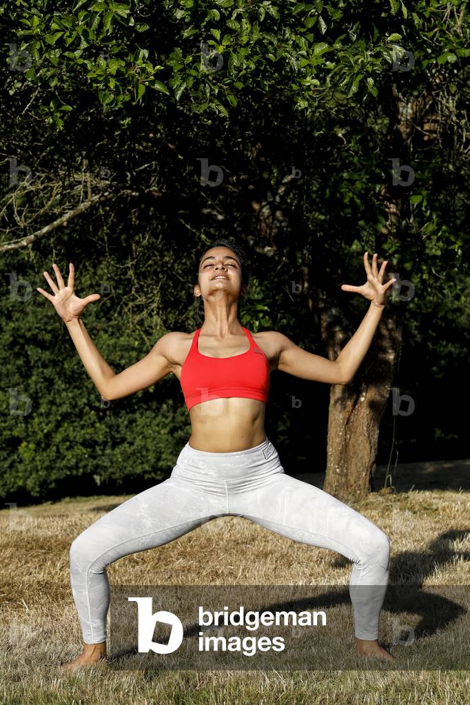 Young woman doing yoga in a garden in Eure, France