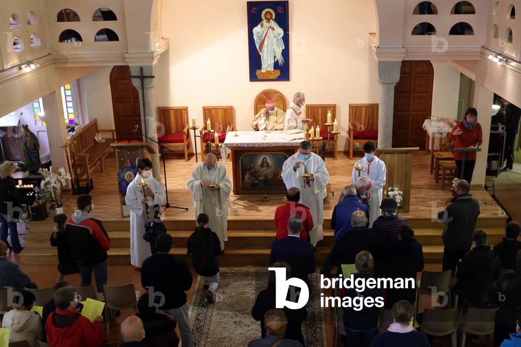 Catholic church during covid-19 epidemic. Sunday mass. Priests giving Holy Communion.  Sanctuary of La Benite Fontaine.