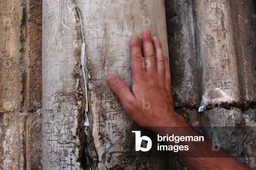 Christian putting his hand on the entrance pillar of the Holy Sepulcher basilica in Jerusalem, Jerusalem, Israel