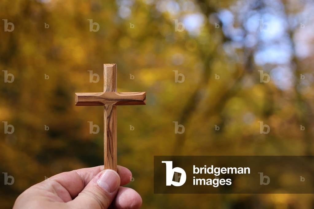 Christian wooden cross in hand. Faith and spirituality.  France.
