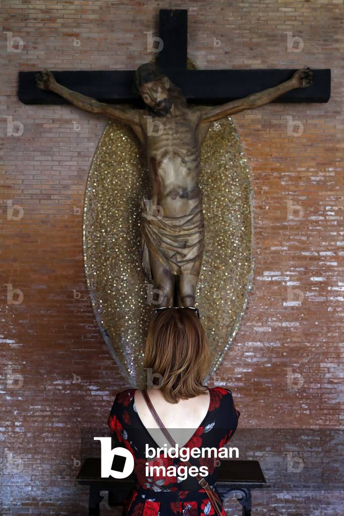 Woman praying Jesus on the cross.