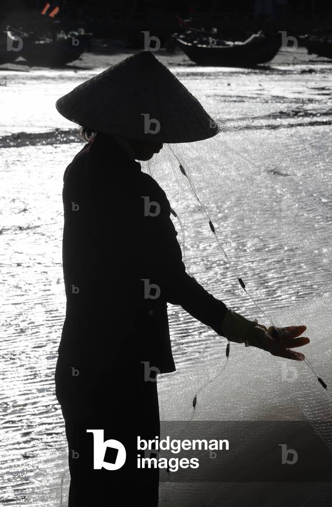 South China Sea, Woman repairing fishing nets, 
 Vung Tau, Vietnam (photo)
