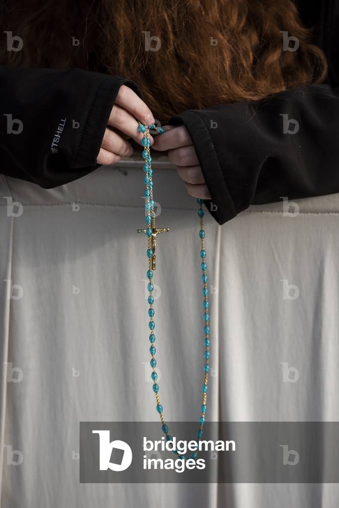 A woman praying the Rosary before a Canonization Holy Mass in Saint Peter's square at the Vatican.