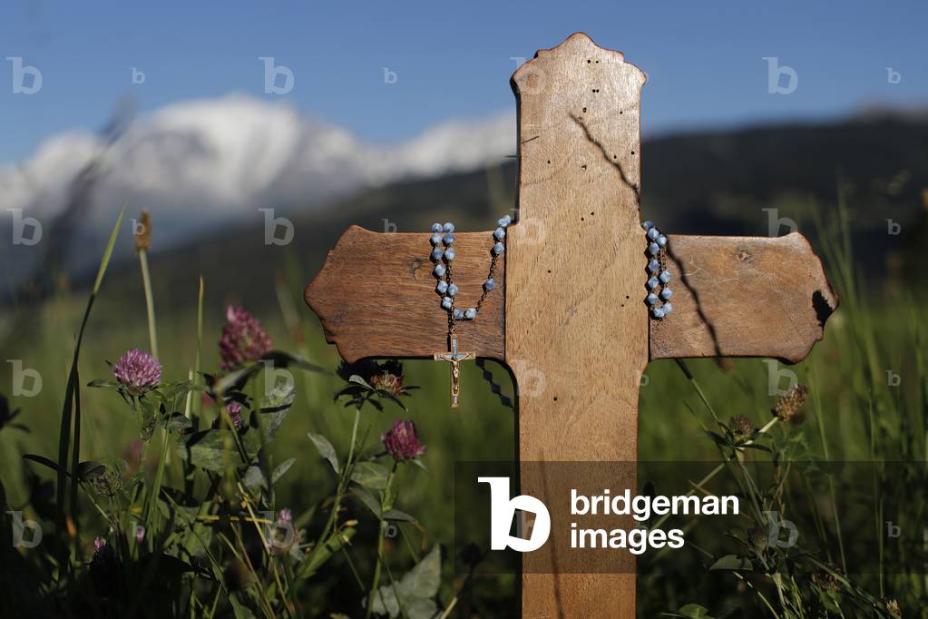 Wooden Christian cross and rosary in nature.  Combloux. France.