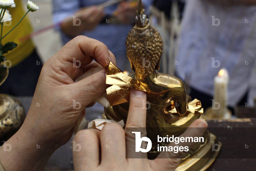 Asalhapuja at Buddhapadipa templeFaithful adding a layer of gold on a Buddha statue, Wimbledon, Grande-Bretagne