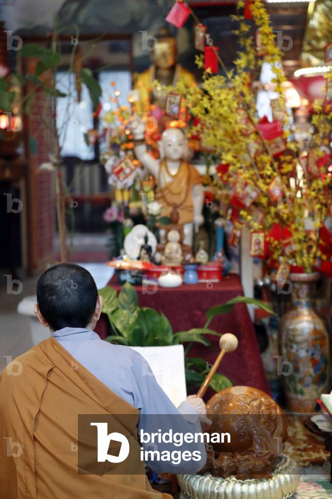 Chua Tu An Buddhist temple, Monk at buddhist ceremony, Monk playing on a wooden fish (percussion instrument), Saint-Pierre en Faucigny, France (photo)