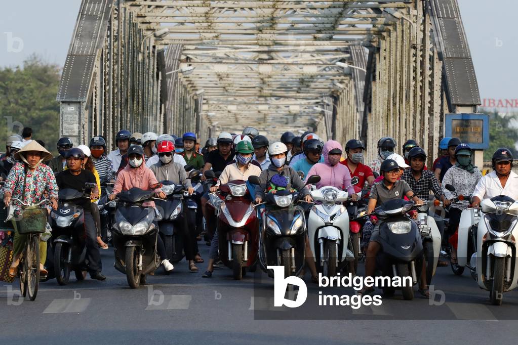 Scooters crossing the famous Trang Tien bridge in morning rush hour traffic, Hue, Vietnam, 2019 (photo)