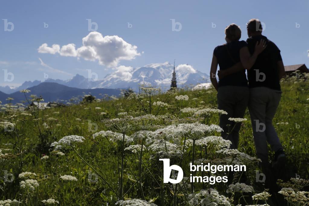 Man and woman walking in the french Alps in summer.   France.
