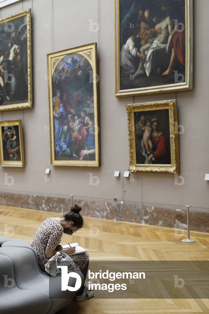 Young woman drawing in the Louvre museum, Paris, France (photo)