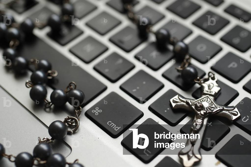 Catholic rosary beads on a laptop keyboard (photo)