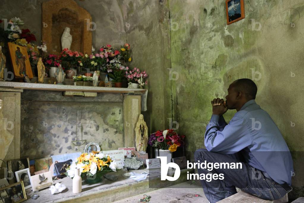 Uomo che prega nella cappella di Notre-Dame de la Gorge. Les Contamines, Francia