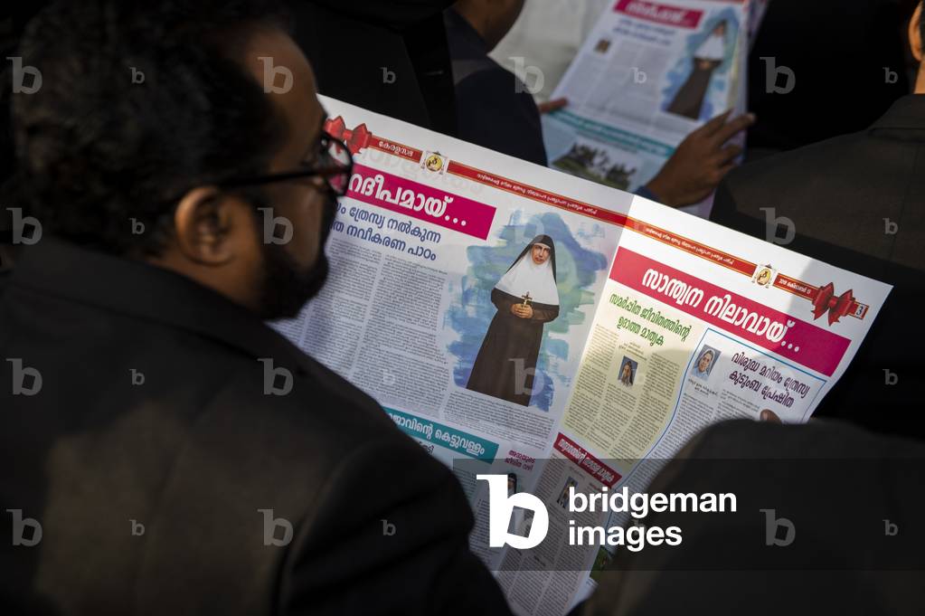 An South Indian faithful reads an Indian newspaper during a Canonization Holy Mass in Saint Peter's square at the Vatican.