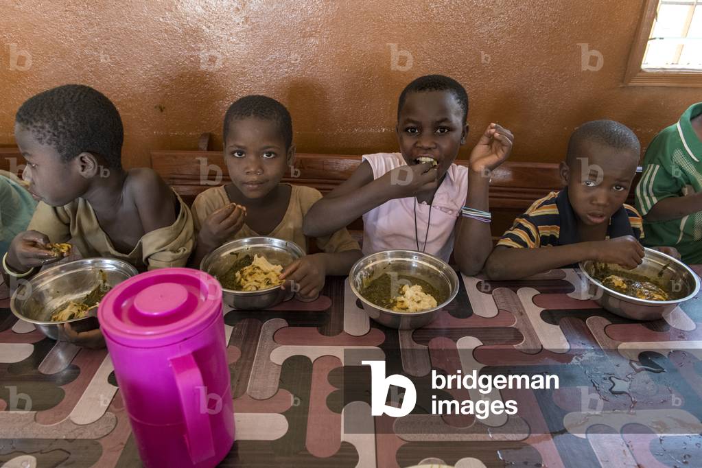 Orphanage run by Vivre dans l'Esperance (living with hope) NGO in Dapaong, Togo. Children having lunch.