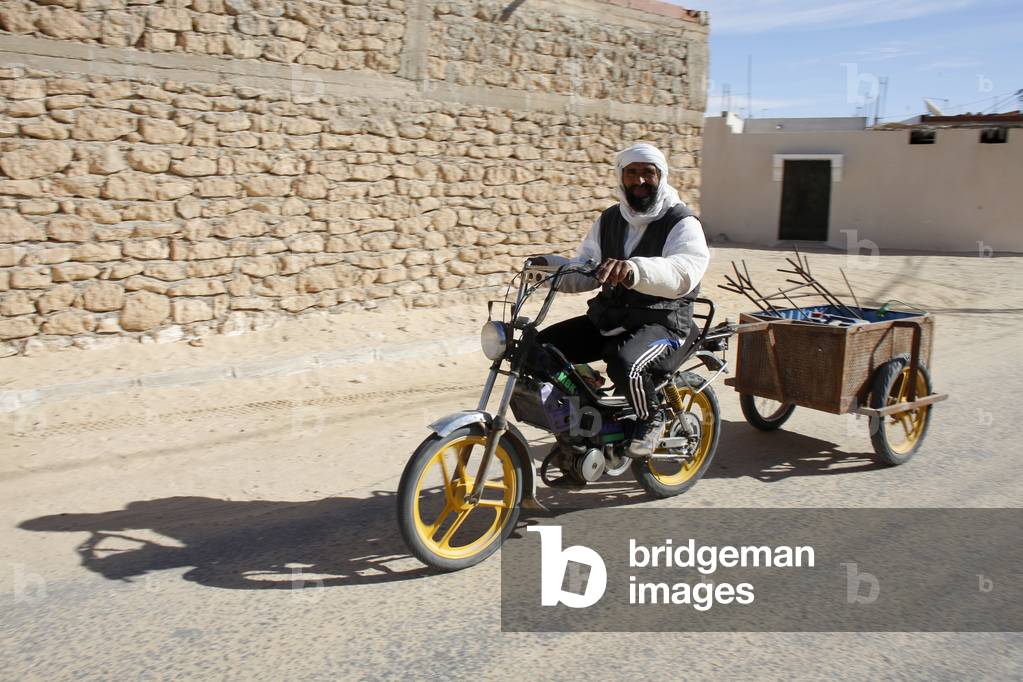 Man driving a moped with a tow, Douz, Tunisie