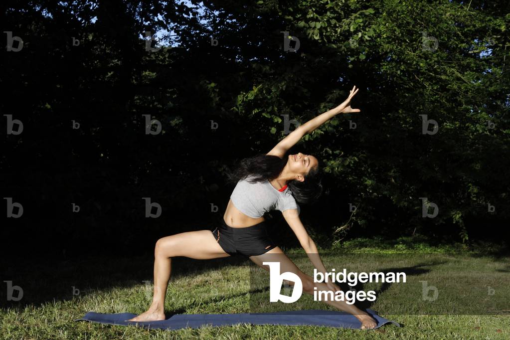 Young woman doing yoga in a garden in Eure, France