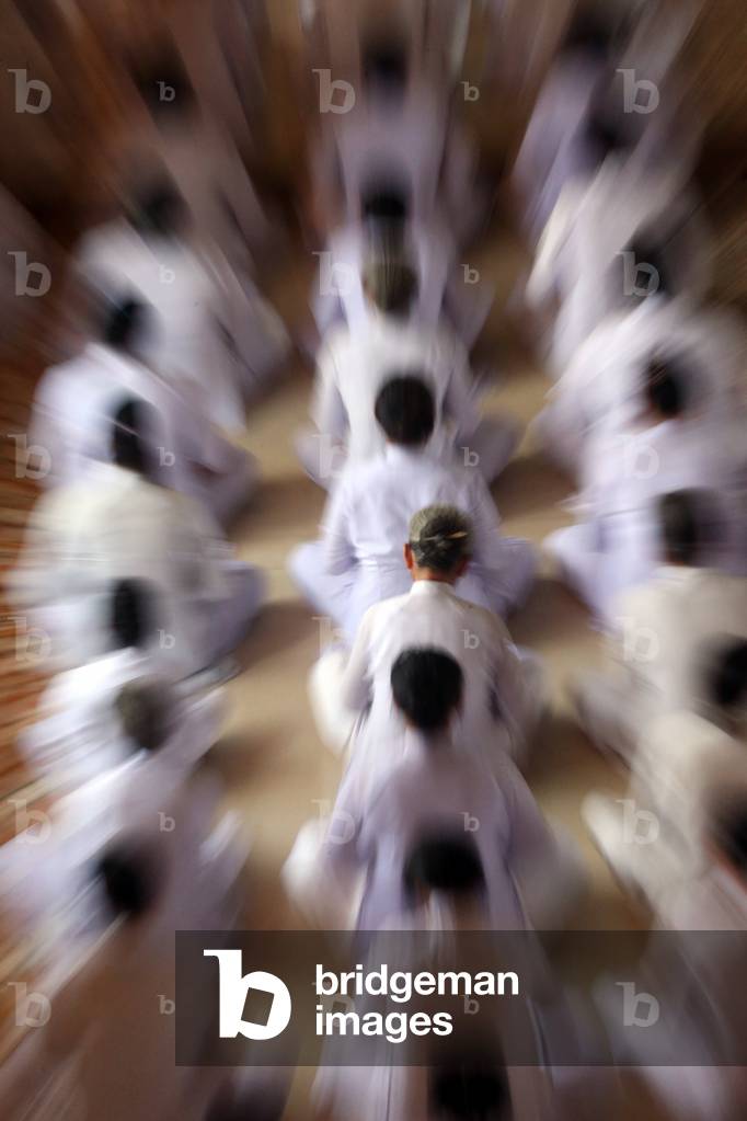 Cao Dai Holy See Temple. Praying devout men, ceremonial midday prayer. Thay Ninh. Vietnam