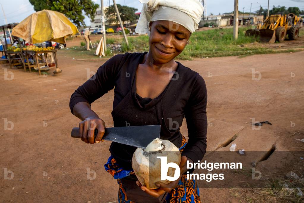 Woman selling coconuts in Daloa, Ivory Coast, 2017 (photo)