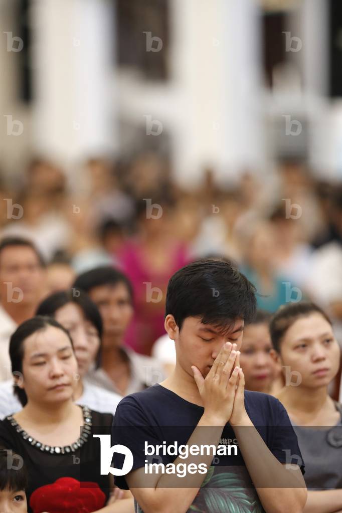 Catholic mass, Young man praying, Thi Nghe Church, Ho Chi Minh City, Vietnam, 2019 (photo)