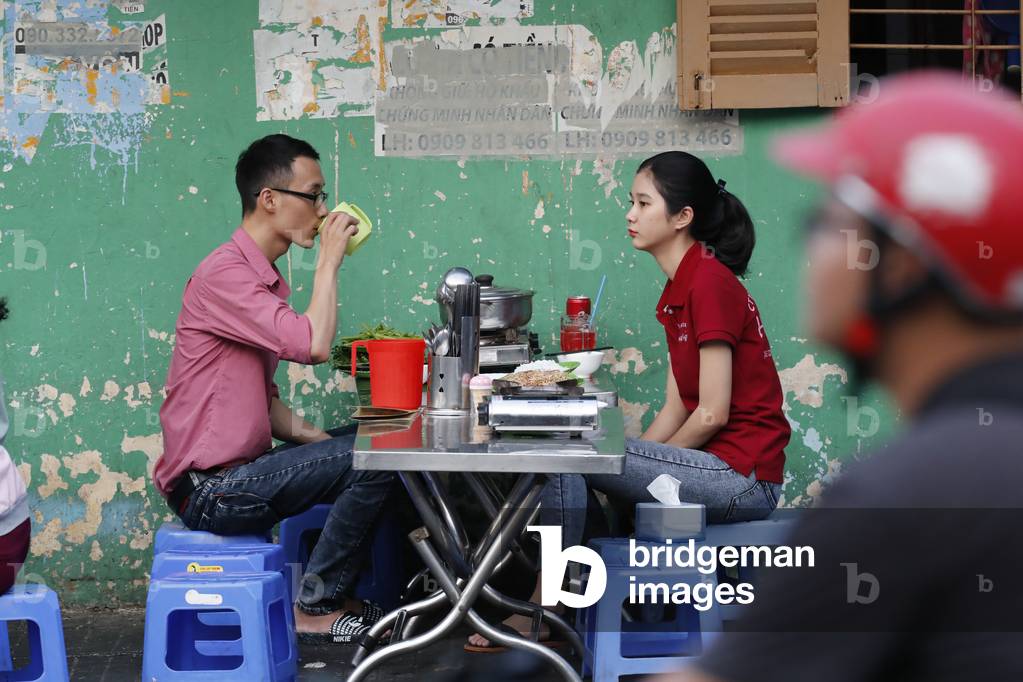 Street vietnamese restaurant, Man and woman having meal, Ho Chi Minh City, Vietnam, 2019 (photo)