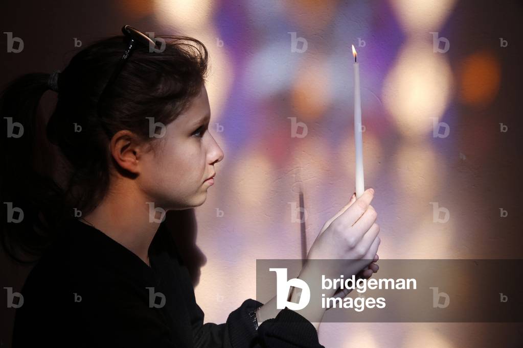 Young girl praying in a church, Les Contamines, France