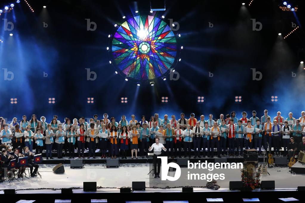 Protestant celebration at the Zenith of Strasbourg, Conductor directing women choir on stage, Strasbourg, France.