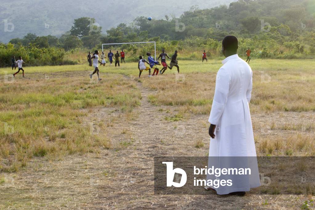 Catholic priest watching a soccer game, Akata Djokpe, Togo