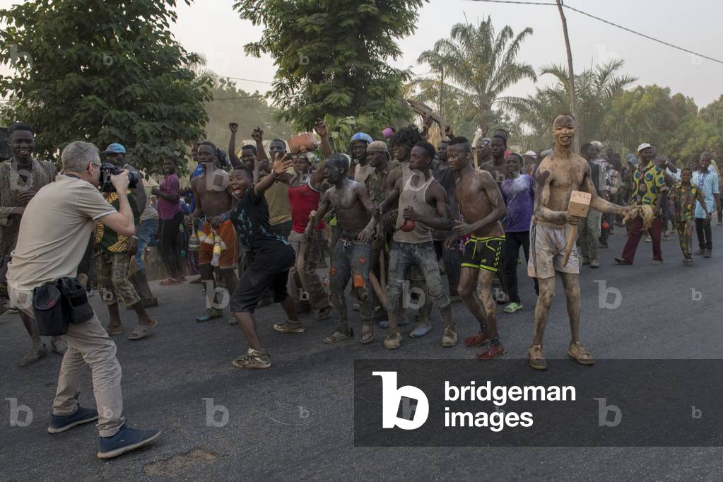 Photographer taking shots of a group of young men gathering for a voodoo funeral near Kara, Togo.