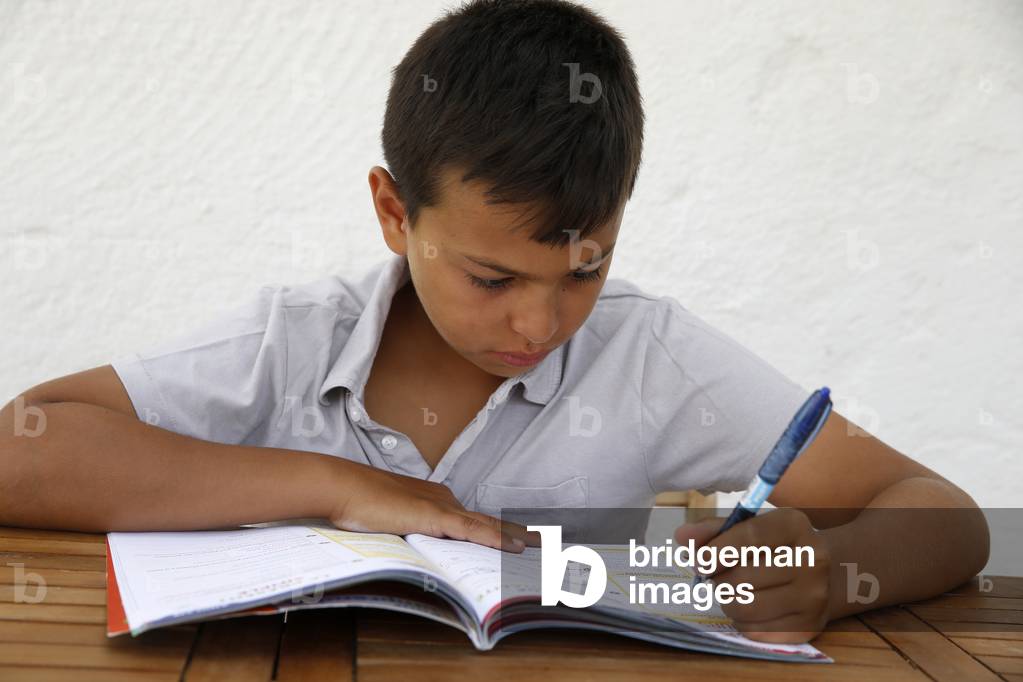 11-year-old boy doing homework in Salento, Italy (photo)