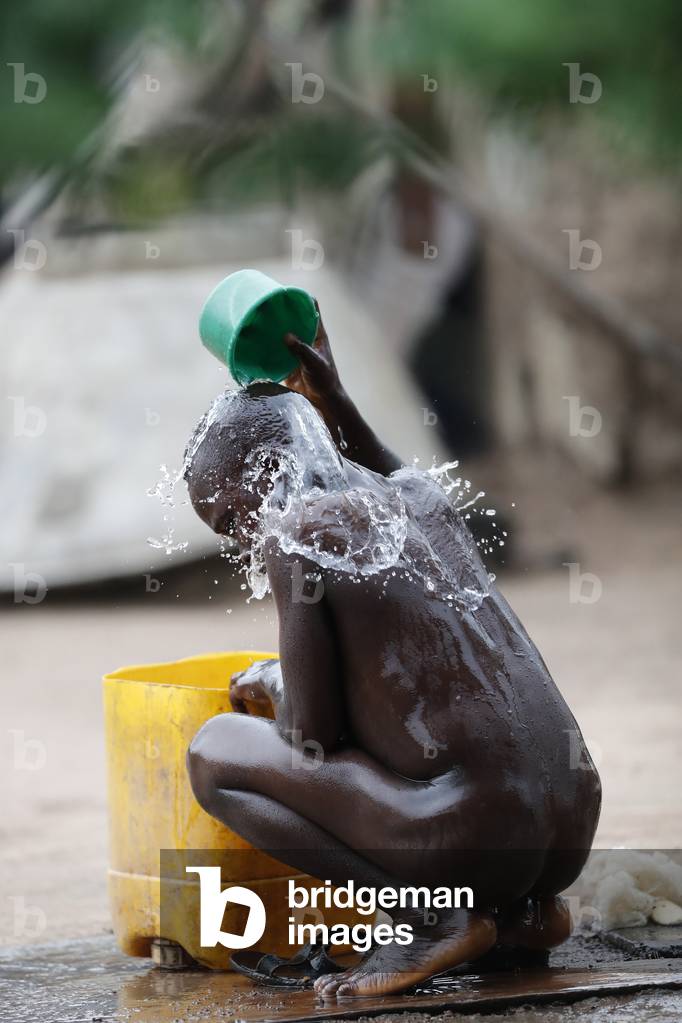 African village, Boy tacking shower, Daily life, Datcha-Attikpaye, Togo, 2019 (photo)