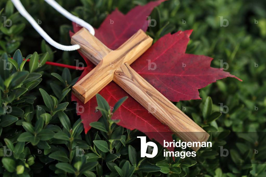 Christian wooden  cross on fall red  leaf. Autumn.  France.