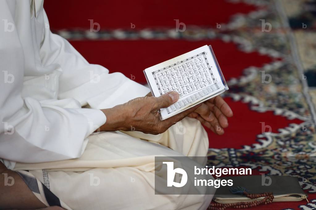 Cholon Jamail Mosque, Muslim man reading the Noble Quran, Ho Chi Minh City, Vietnam, 2019 (photo)