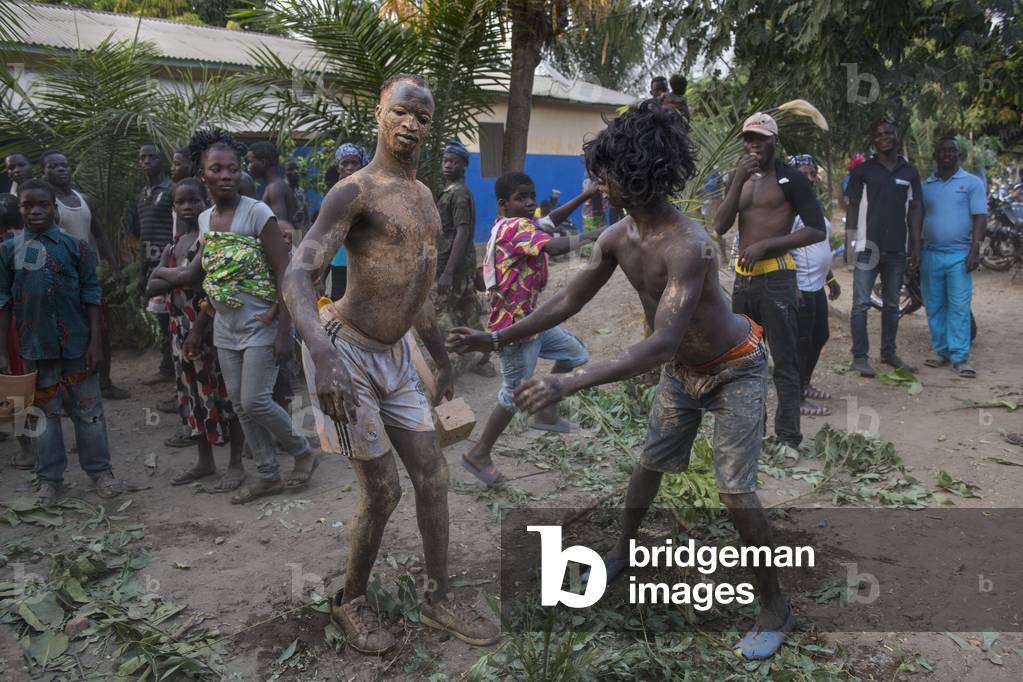 Drunk young men dancing at a voodoo funeral near Kara, Togo.