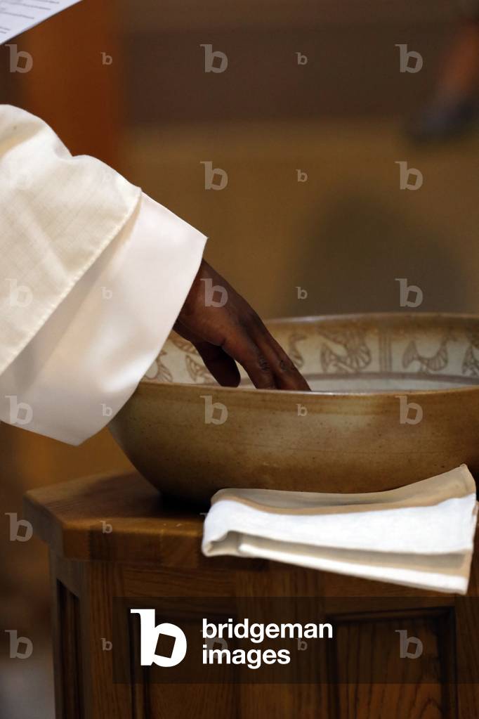 Catholic church. Baptismal liturgy.  Catholic priest celebrates baptism.  France.