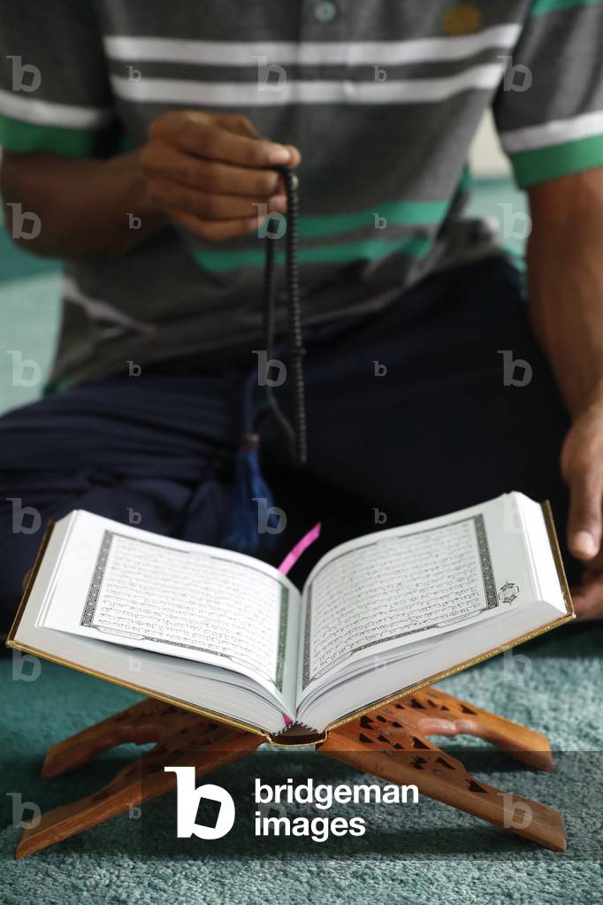 Muslim with Tasbih (prayer beads) and Quran in Mosque.  Ho Chi Minh city. Vietnam.  (photo)