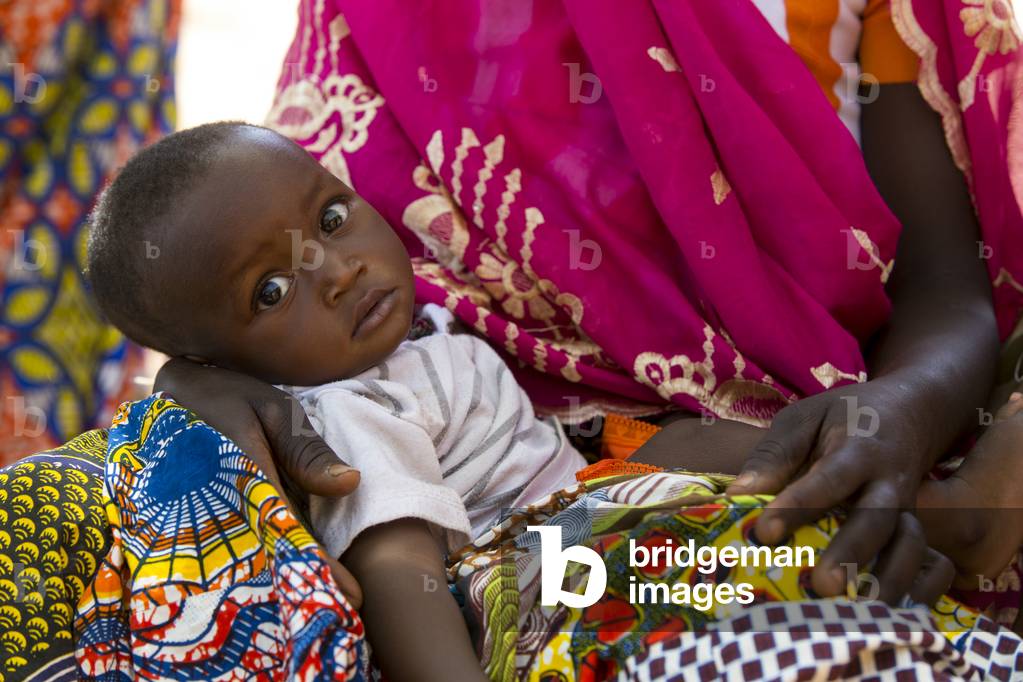 Child on his mother's lap in Northern Togo (photo)