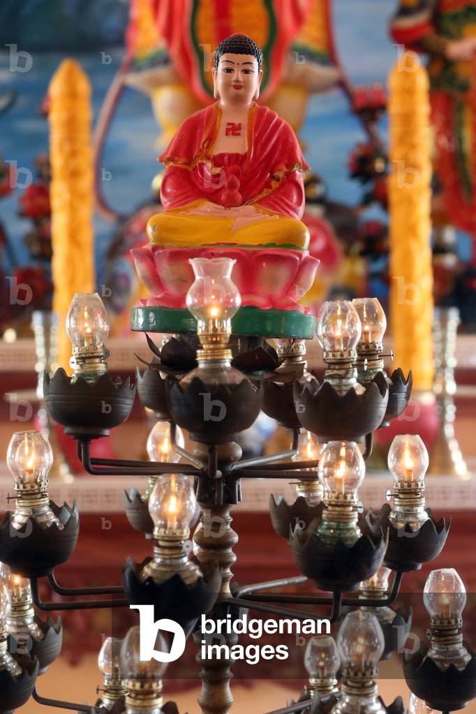 Chua Thiep Long buddhist pagoda. Oil lamps befor Buddha. Thay Ninh. Vietnam