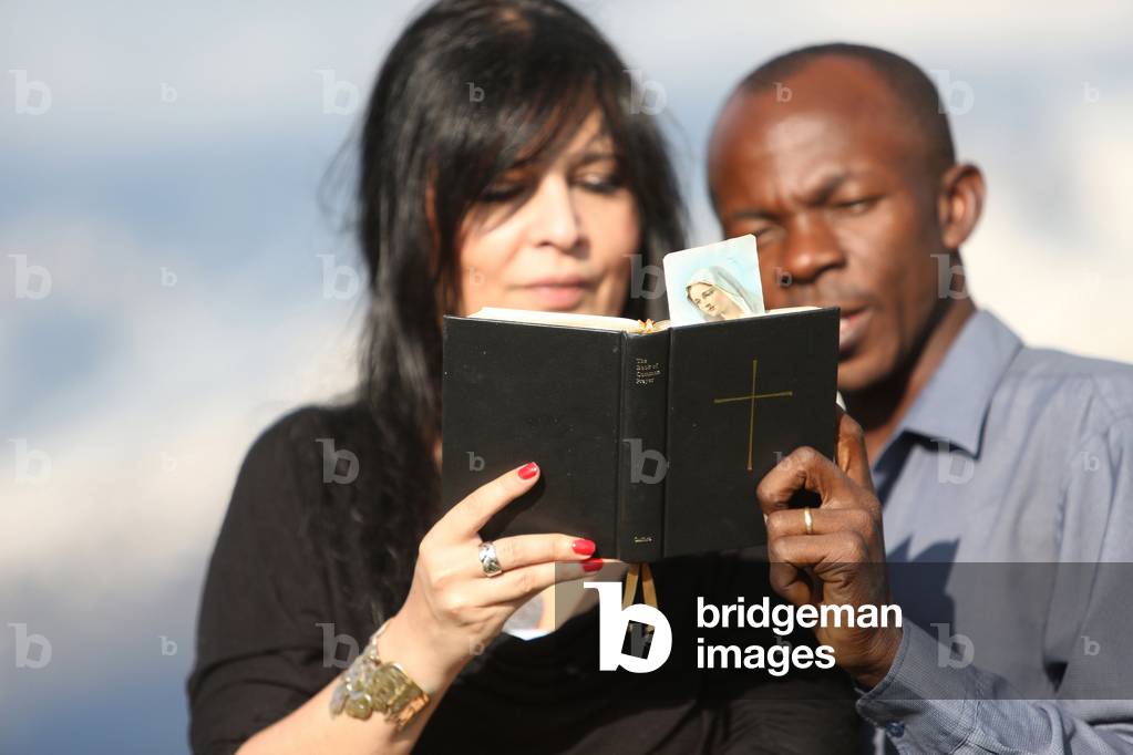 Man and woman reading the bible outside. Saint-Gervais France