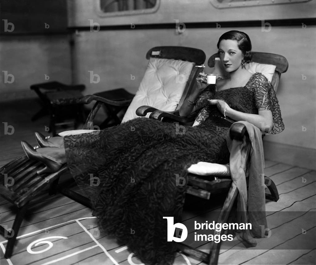 Gertrude Lawrence,   in role, reclining on a deck chair in an ocean liner set
