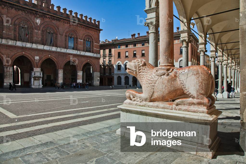 View of Piazza del Comune (Town Hall Square) with one of the Column with lions of the main Portal of the Duomo and the Porch of the Bertazzola, Cremona, Lombardy, Italy (photo)