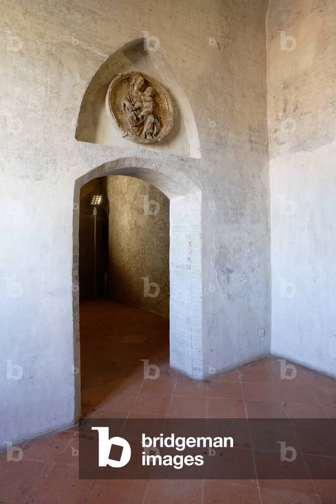 The door to the Contrari Chapel. In the niche, there is a tondo in scagliola (fifteenth-century style), depicting a Madonna with Child, in the variant called Madonna of Humility, The Contrari Chapel, Vignola Stronghold, c.1420 (photo)