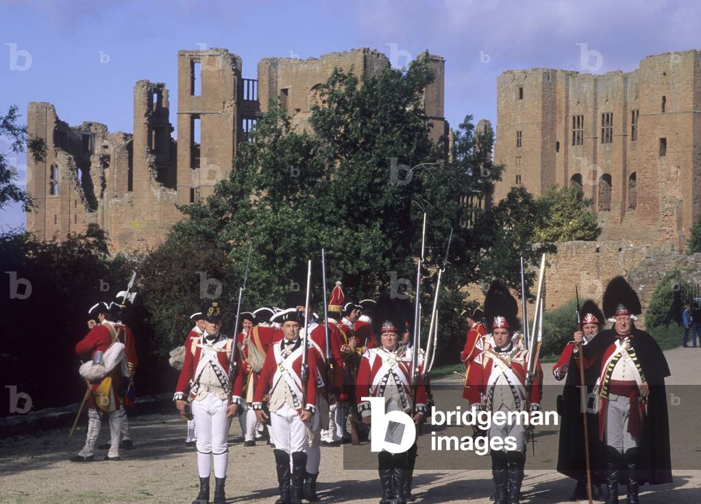 Eighteenth century redcoats outside Kenilworth Castle, Warwickshire, part of a historical re-enactment (photo)