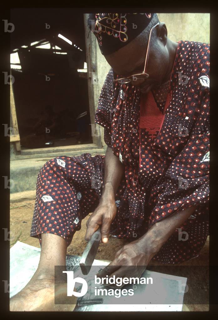 Asiru Olatunde engraving an aluminium panel