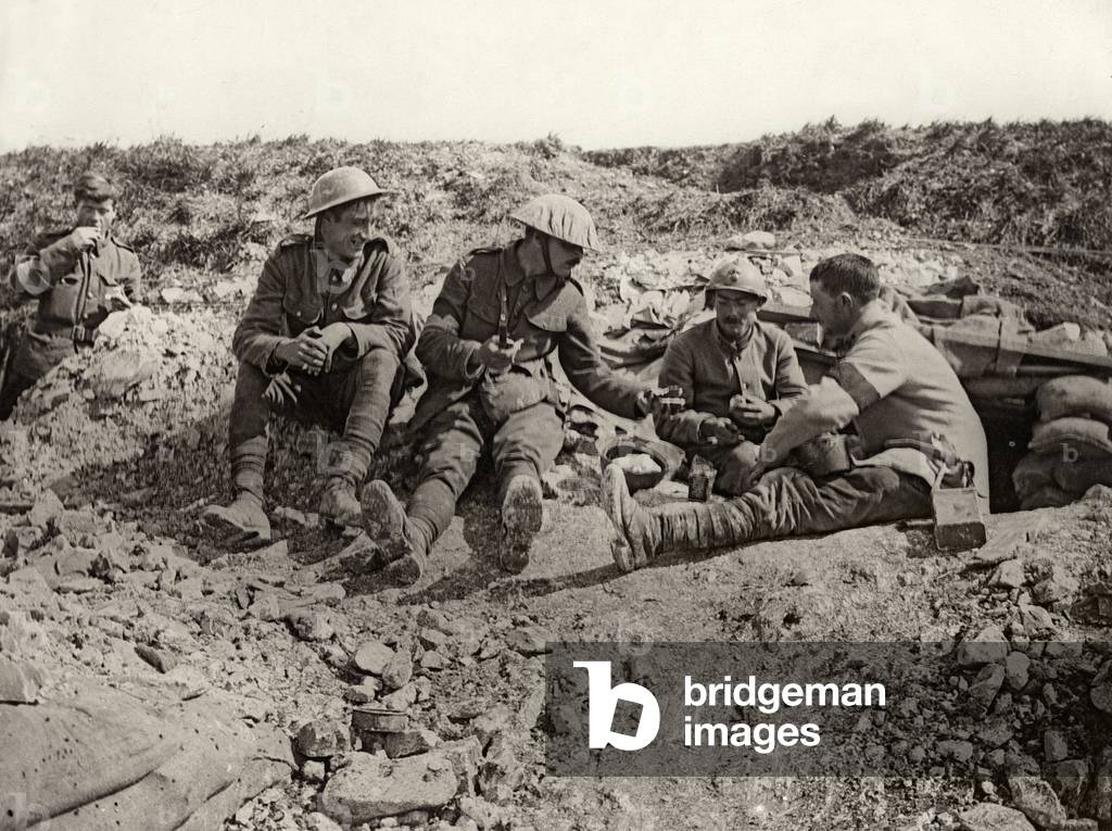 French and British soldiers share rations at the front, France, 1914-18 (b/w photo)