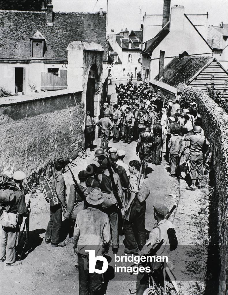 Groups of French Resistance fighters wait for the distribution of weapons in a house, July 1944 (b/w photo)