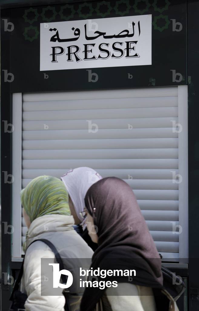 Muslim veiled women in front of a newsstand (press office) farm, Fes (Fez), Morocco. Photography