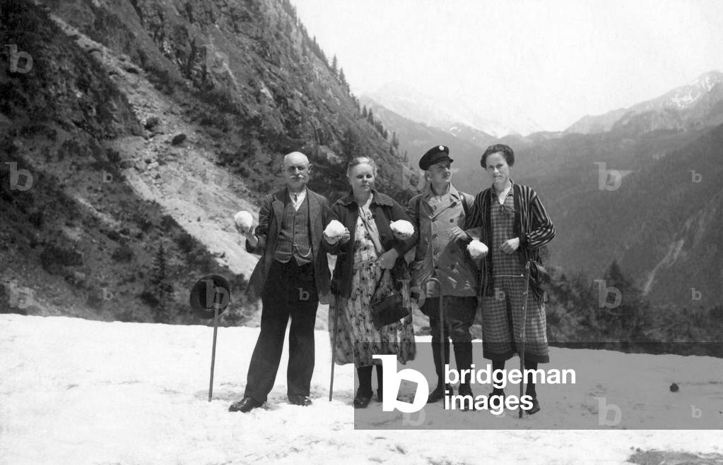 Four people apprehending a snowball battle.