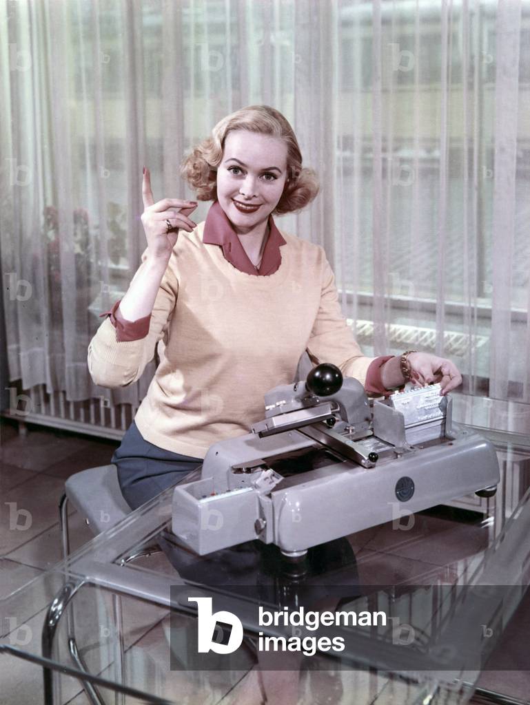 Secretariat: Woman sitting in front of a writing machine. photography around 1955