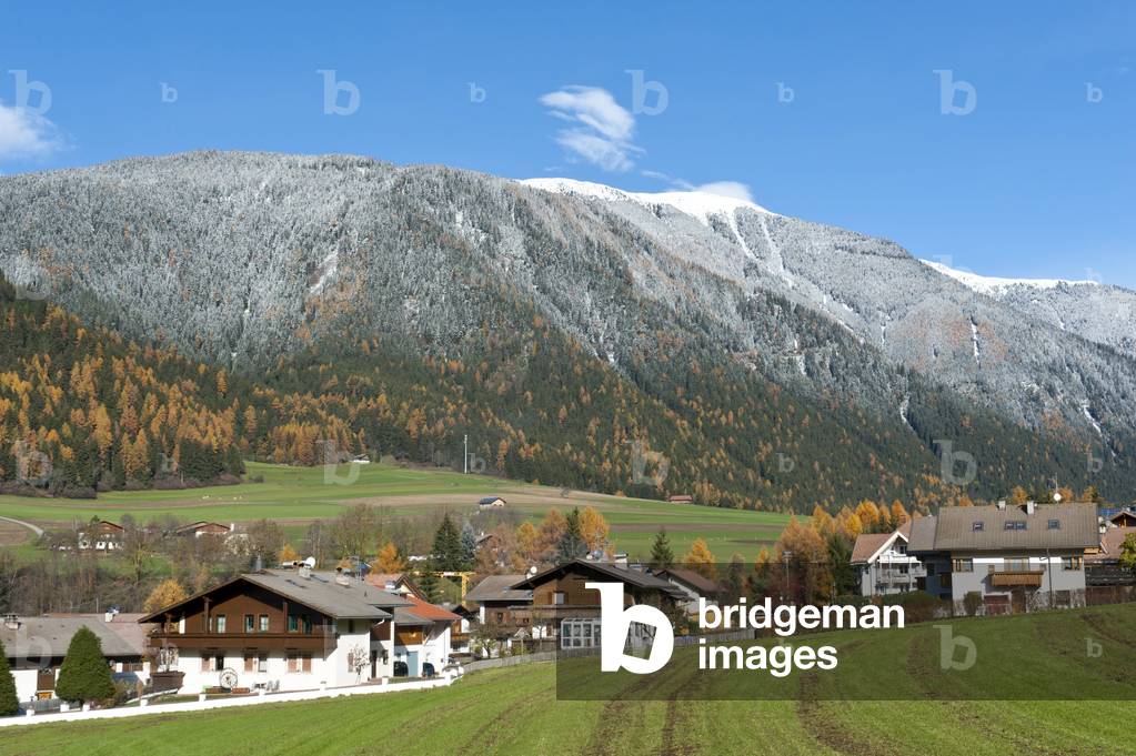 Autumn in the Alps; view over a village towards the autumnal snow-covered forest and Hochnall Mountain; 2337 m; Niederrasen; Rasen-Atholz; Rasun di Sotto; Anterselva; Alto Adige; Trentino-Alto Adige; Italy; Europe